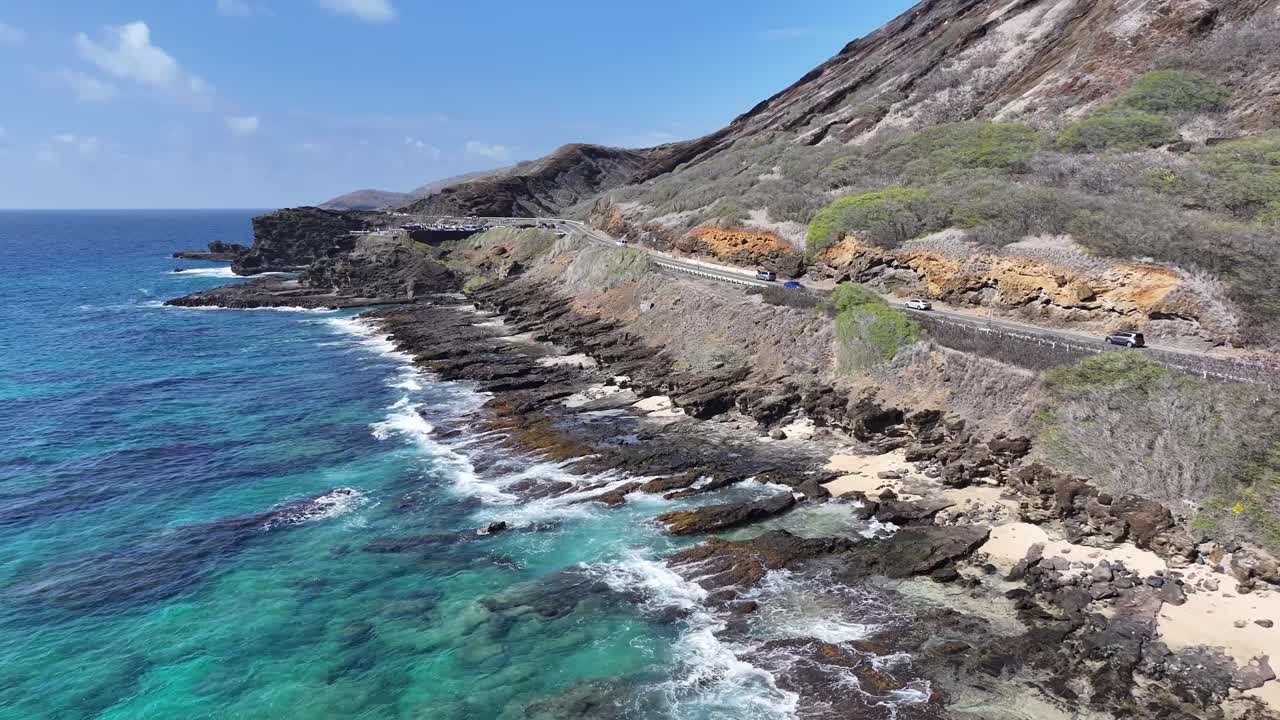 Aerial drone footage over Hawaii’s lush green mountains and tropical coastline, showcasing turquoise ocean waters, palm trees, scenic valleys, and vibrant island landscapes from above