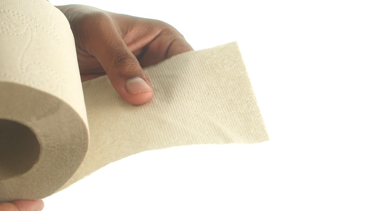 Hand holding a roll of toilet paper