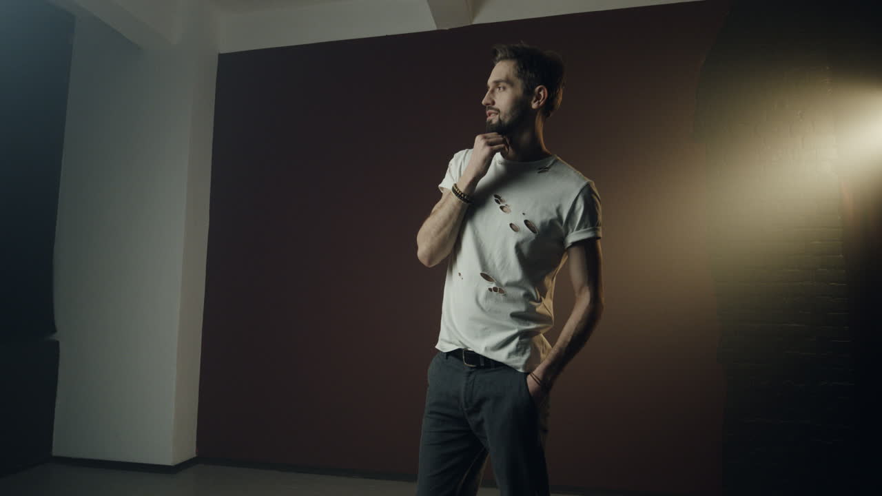 cámara acercando y alejando al joven modelo caucásico posando profesionalmente a la cámara en el estudio