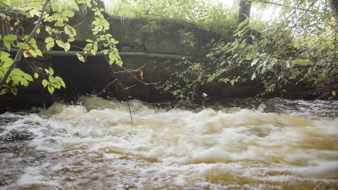 강한 비가 내린 후 강한 홍수 물 흐름이 폭우 하수구에서 빠져나옵니다.