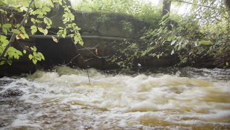 strong flow of floodwater after heavy rainfall exits storm drain
