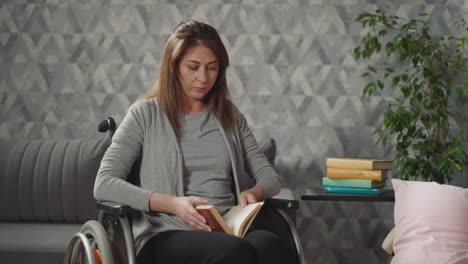 young woman takes book with brown cover from stack on table