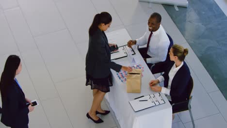 businesswoman checking in at conference registration table 4k