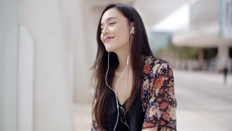 Mujer-Joven-De-Moda-Escuchando-Música-En-La-Ciudad.