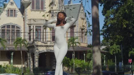 a young girl in a white bodysuit enjoys a city day with stollmeyer castle in the backdrop