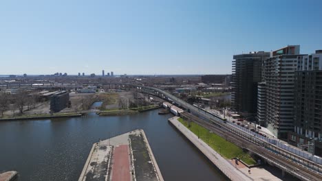 Drone-Siguiendo-El-Tren-Subterráneo-Rem-Conduciendo-Por-La-Ciudad-De-Montreal-En-Quebec-Durante-Un-Día-Soleado