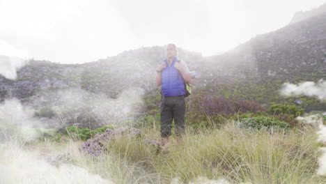 hombre caucásico de edad avanzada caminando de pie en el campo, sobre nubes de rápido movimiento