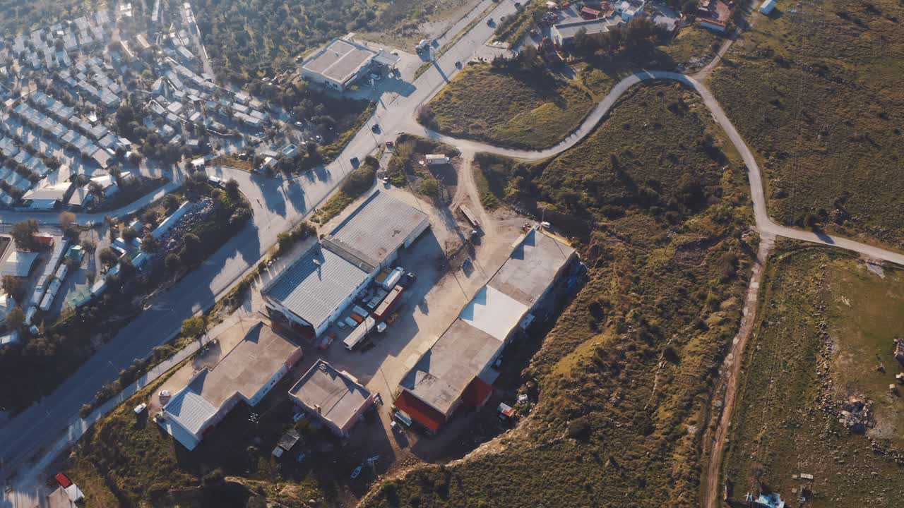 Aerial View Over Warehouse Beside Road Near Coastline In Mitilini, Lesbos. Follow Shot
