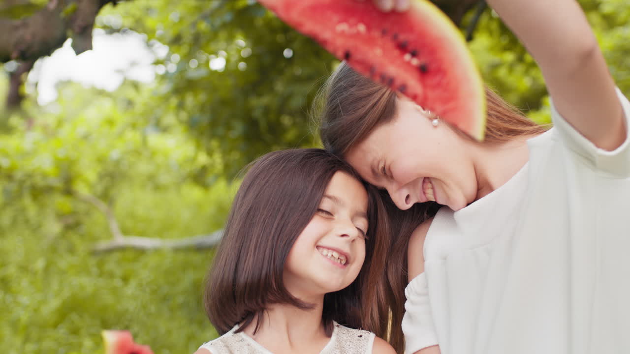 두 소녀 가 수박 을 즐기고 있다