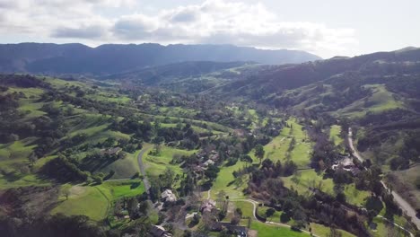 country side lush green mountains, covered with trees, under a blue sky with clouds move forward