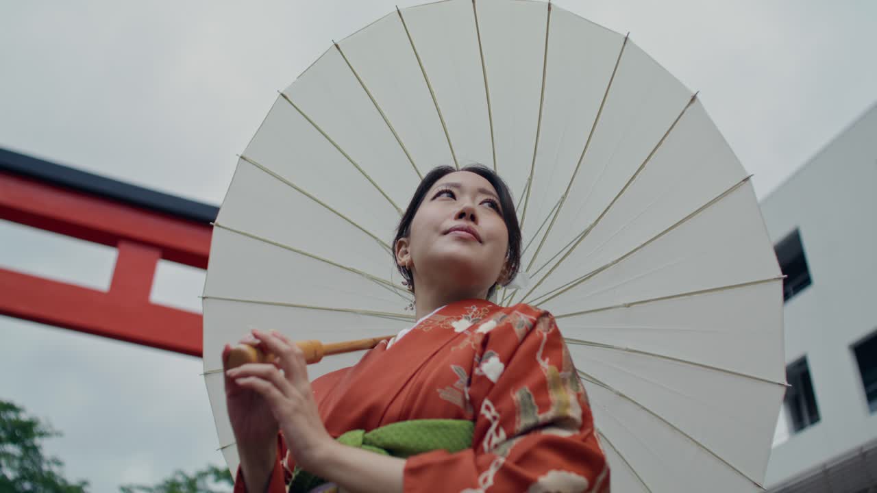 Woman in Kimono with Umbrella at a Torii Gate