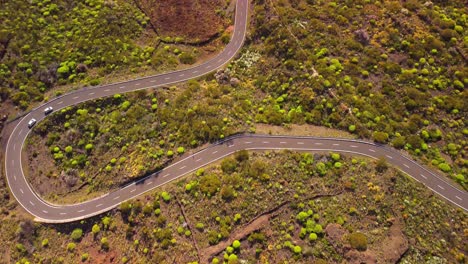 Luftaufnahme-Von-Oben-Nach-Unten-Von-Zwei-Autos,-Die-Auf-Einer-Kurvenreichen-Straße-Im-Vulkangebiet-Des-Teide-Fahren