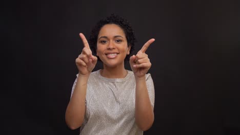 leisure-and-people-concept--happy-african-american-woman-dancing-and-showing-thumbs-up-over-black-background