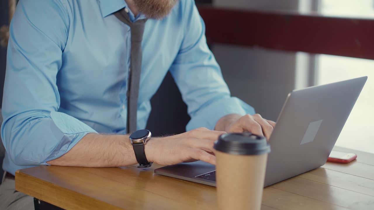 Uomo d'affari che lavora al portatile in un caffè