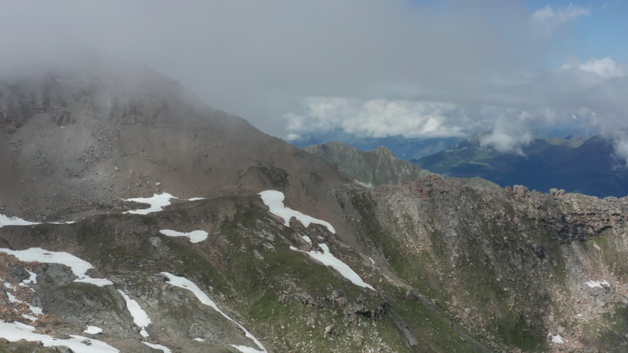 antena de la ladera de una montaña rocosa con espesas nubes oscuras formando