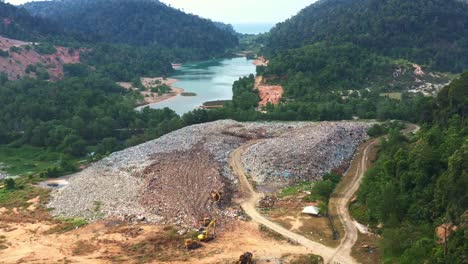 massive landfill site with unsorted wastes, showcasing environmental sustainability, microplastics and causes of global warming and climate change, aerial drone flyover