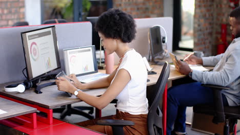 African American woman working on tablet at her desk in office