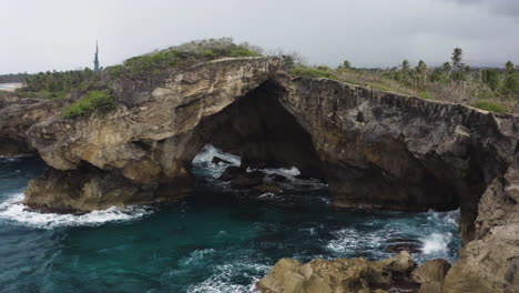 el indio cave in las piedras, puerto rico with waves crashing on cliffs - aerial drone shot