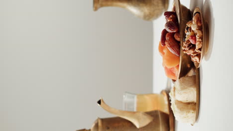 hand picking dates from a bowl of dried fruit and nuts