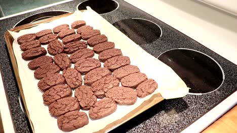 a person takes the cookies out of the oven