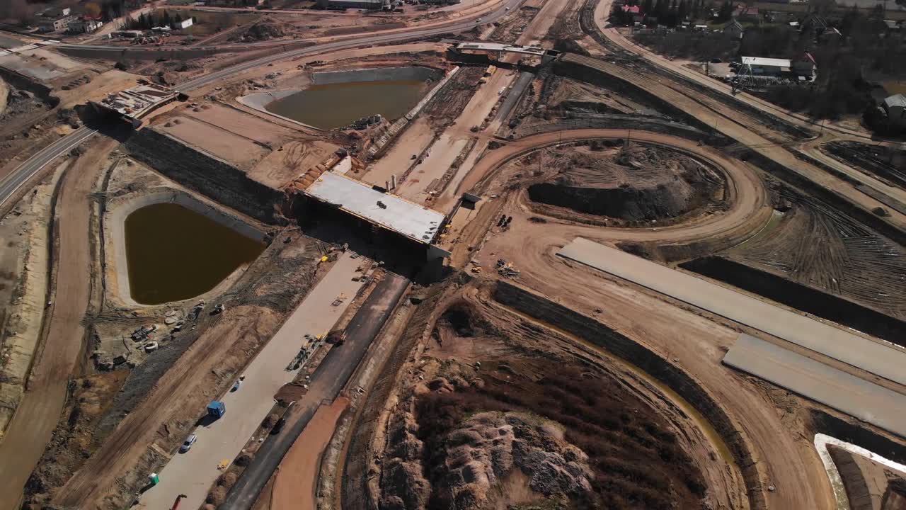 Aerial backwards fly over the large scale highway intersection construction project