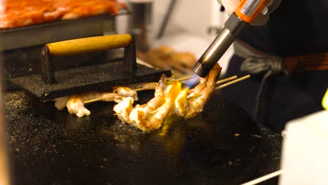 shrimp skewers being grilled on a hot surface