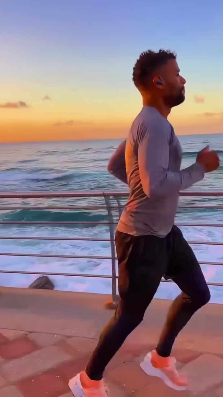 Uomo che corre lungo il lungomare al tramonto