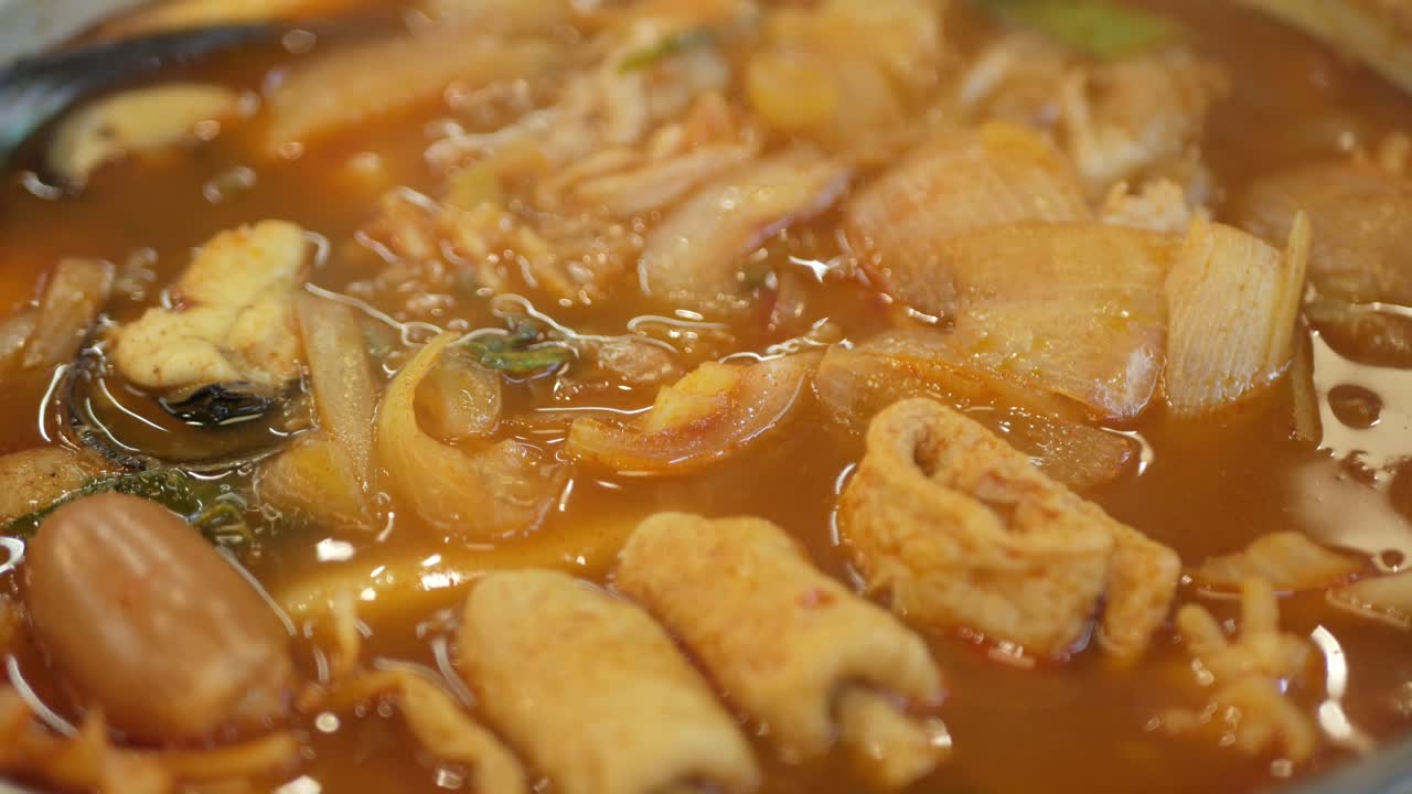 cerca de la sopa hirviendo de kimchi coreano tteok pokki llena de carne de cerdo y vegetales