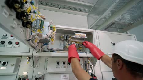 electrical engineer working check the electric current voltage and overload at front of load center cabinet or consumer unit for maintenance in main power distribution system room.