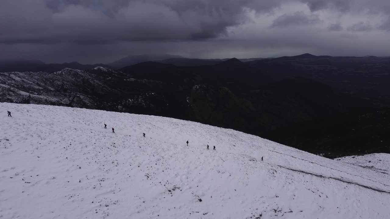 눈 덮인 산봉우리를 오르는 멀리 떨어진 사람들의 눈에 띄는 공중, 앞으로, 하루