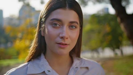 closeup serene woman smiling in park with soft golden sunlight. portrait beauty