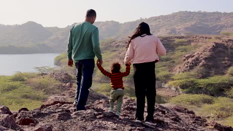 isolate infant holing parent finger and walking at mountain top at day