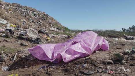 A-lilac-tablecloth-in-the-foreground-at-a-waste-dumping-ground