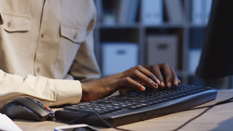 Nahaufnahme-Der-Finger-Des-Mannes,-Die-Nachts-Auf-Der-Schwarzen-Tastatur-Des-Computers-Im-Büro-SMS-Schreiben