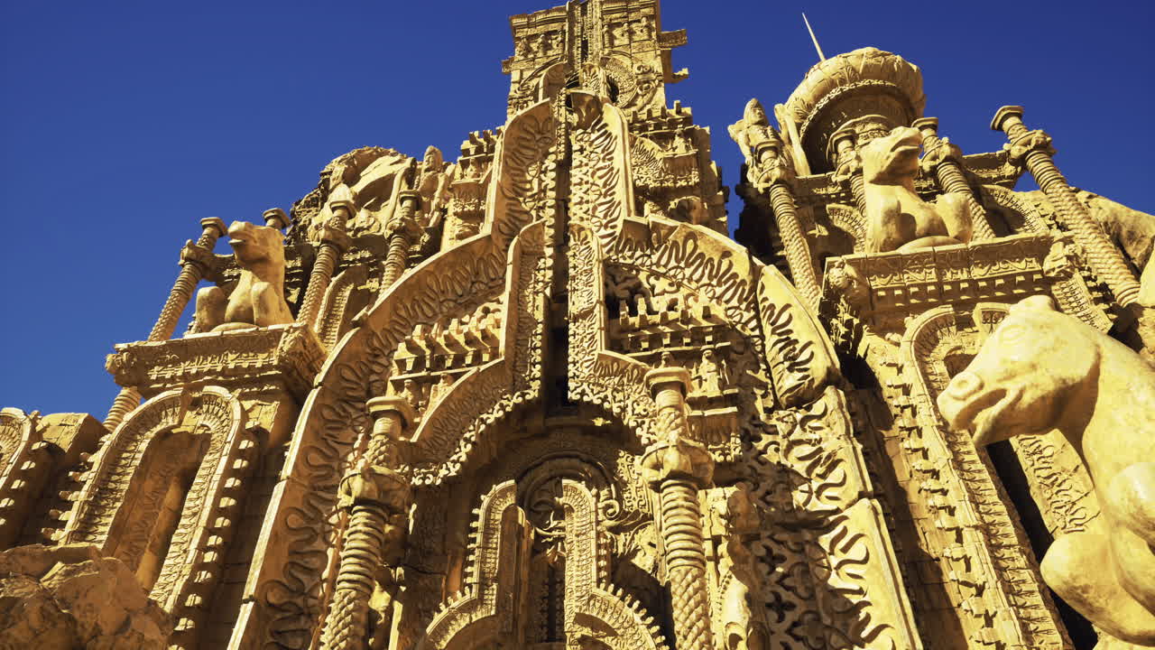 Ornate stone structure adorned with intricate carvings under clear blue sky