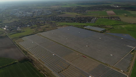 High-angle-view-of-large-solar-park-on-field-on-city-outskirts.-Green-energy,-ecology-and-carbon-footprint-reduction-concept