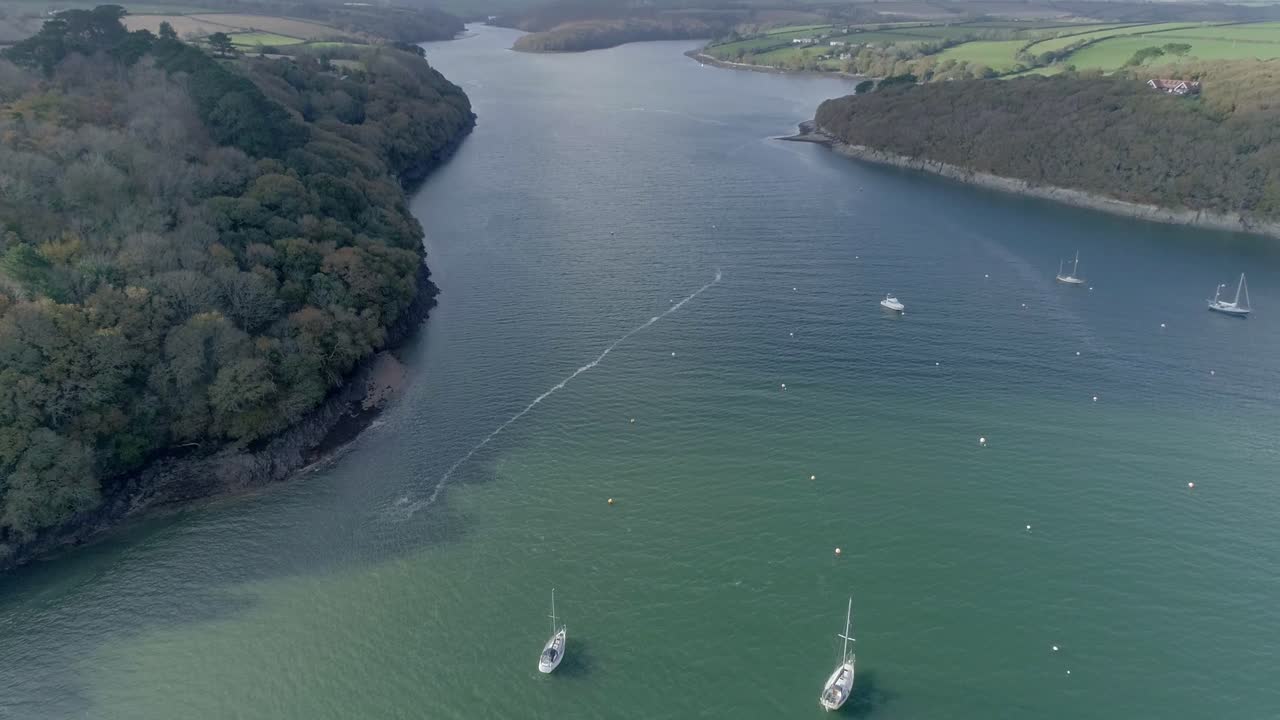 vista aérea, inclinándose hacia abajo sobre los barcos en un estuario en cornwall, inglaterra