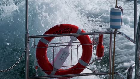 life ring with light and other safety equipment on the back of a moving motor boat