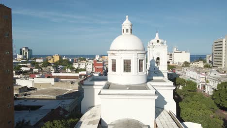 drone rises above the cathedral of santa marta to reveal the sea of port in the distance