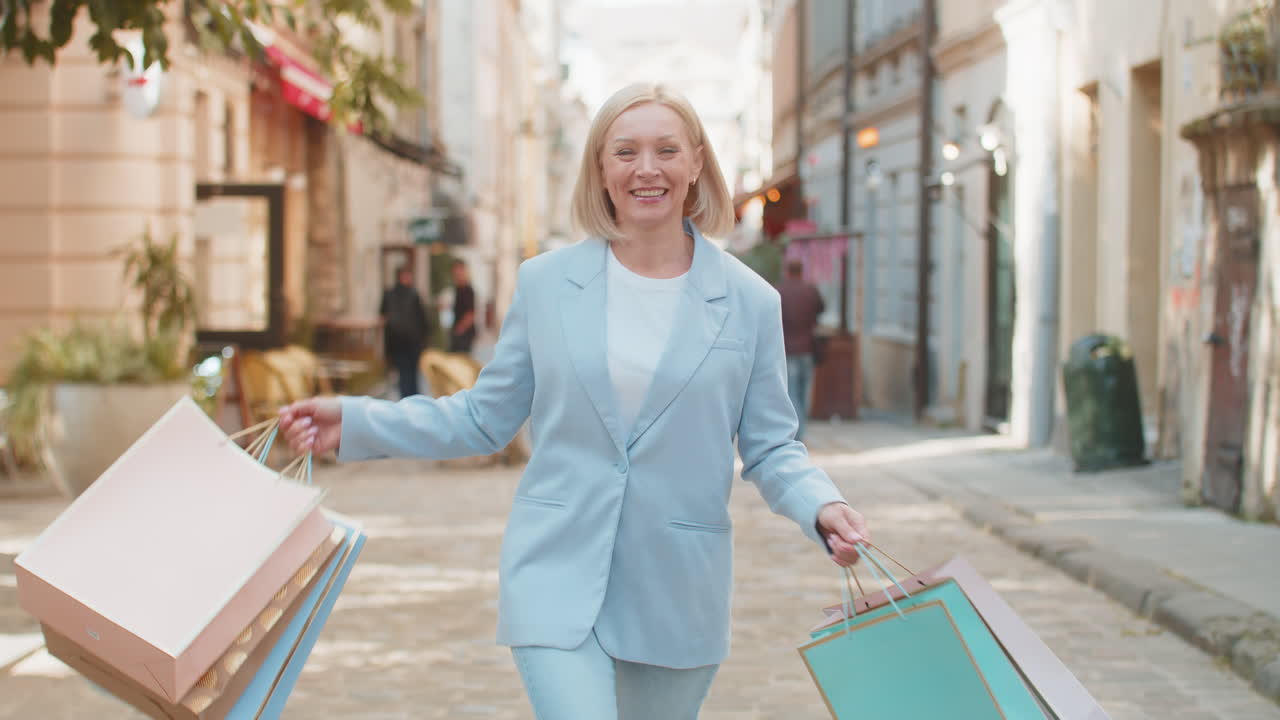 구매 후 도시 거리에서 는 동안 쇼핑 가방을 들고 있는 성숙한 사업가