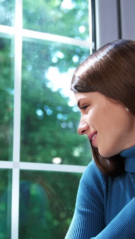 beautiful smiling brunette in warm blue dress and black boots on a tractor soles. model posing on a window sill. nature backdrop. vertical video