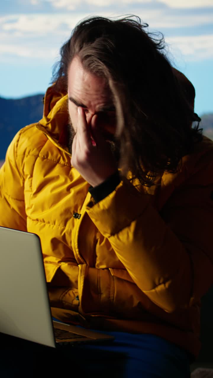 Frustrated Bearded Man Working on Laptop in Mountains