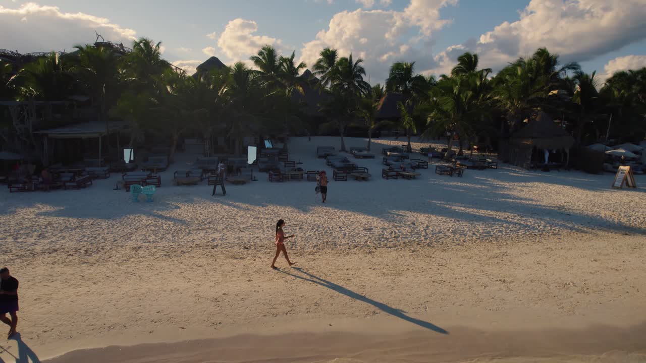 volando sobre la gente caminando en la playa de akiin y nadando en el hermoso mar verde