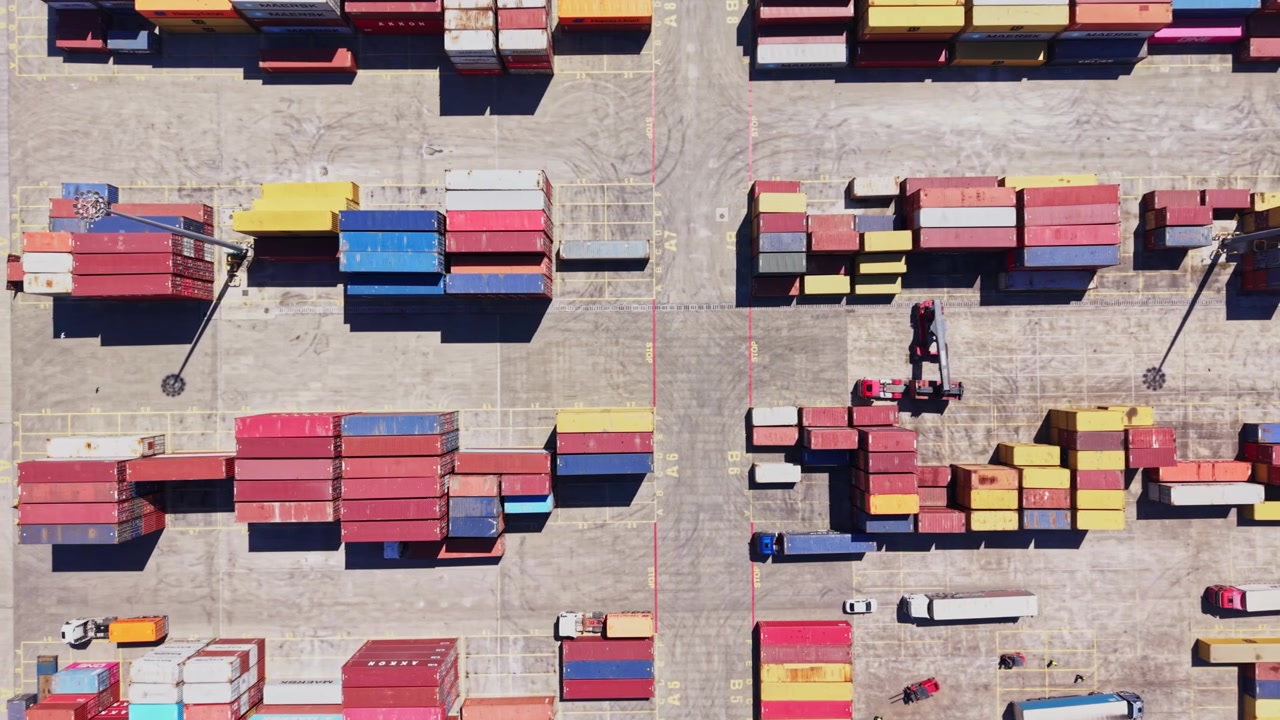 Cargo containers arranged in a busy freight yard during daytime
