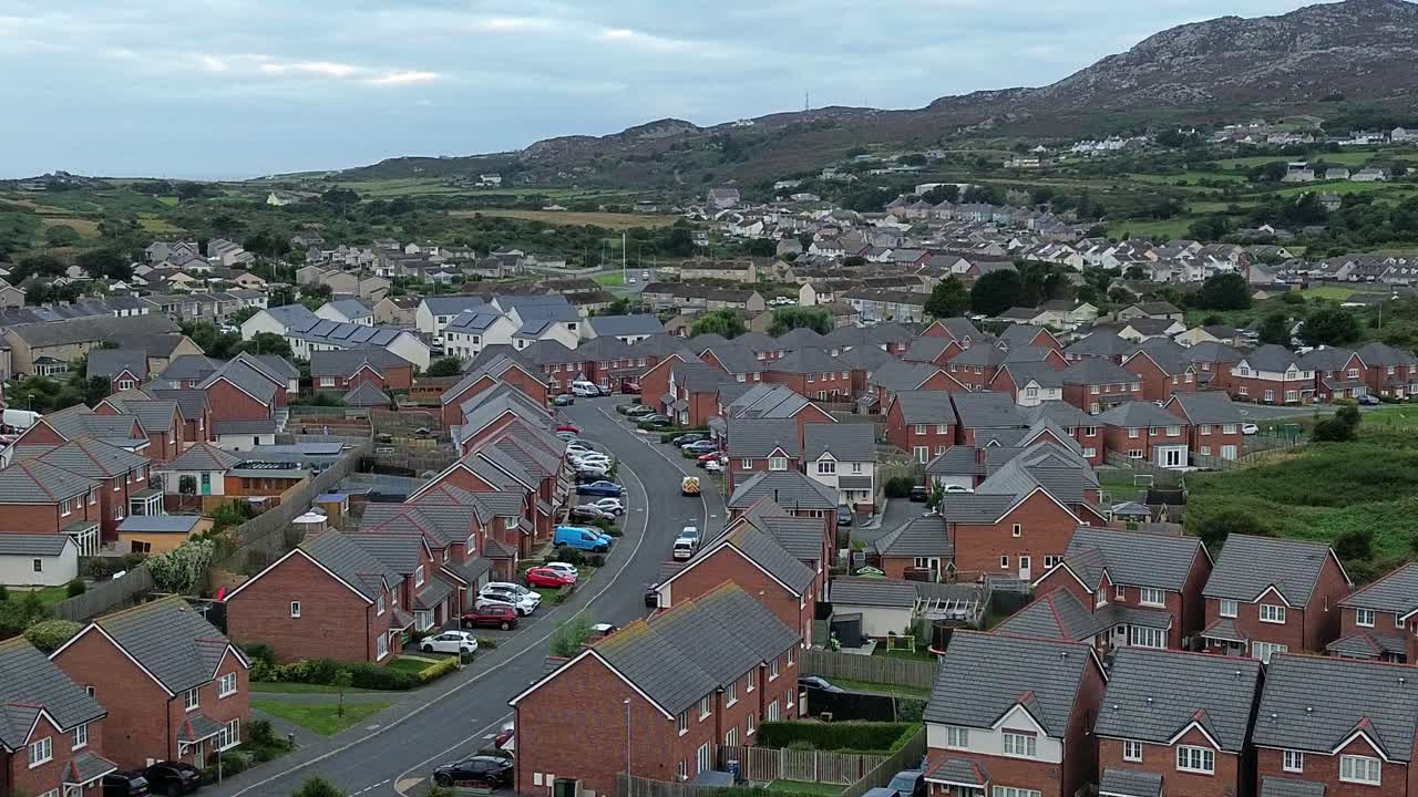 Welsh townhouse modern property development aerial view flying towards rocky mountain