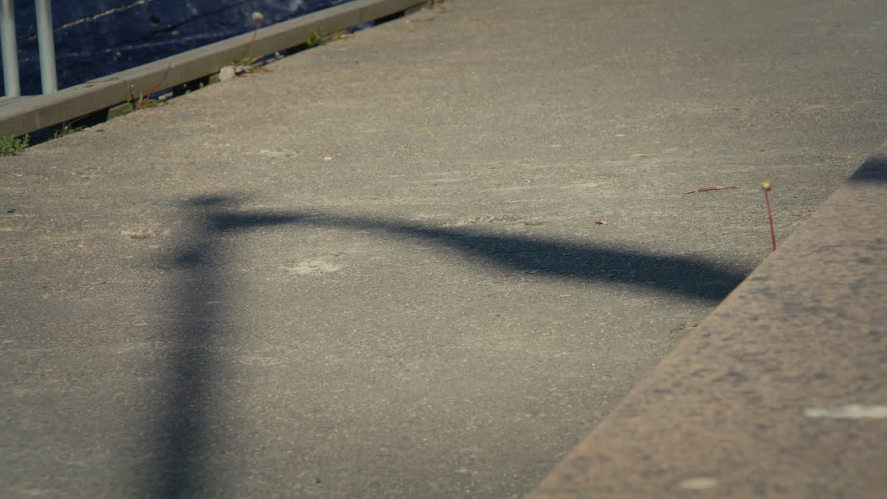 Slow motion medium shot of the shadow of a flag waving in the wind, cast on the pavement in Arendal, Norway
