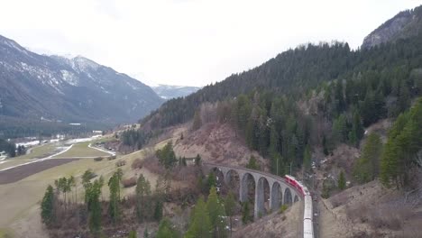 aerial view of the famous bernina train moving on the railroad