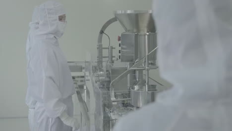lab workers in washing gloves on pharmaceutical production line in modern factory, laboratory worker filling vials with liquid, scientist testing medical vials on conveyor belt