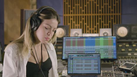 joven caucásica que trabaja en un estudio de grabación de música