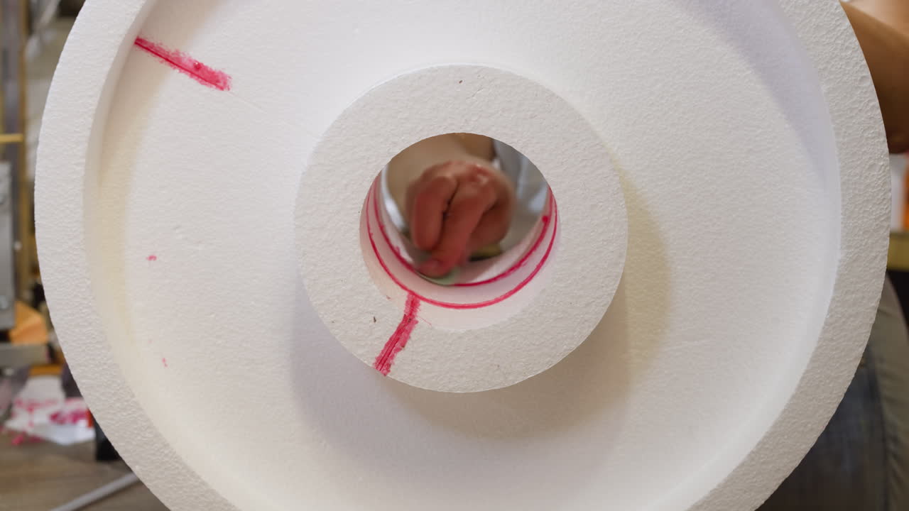 primer plano de un rollo de espuma de poliestireno con marca roja, mano en movimiento